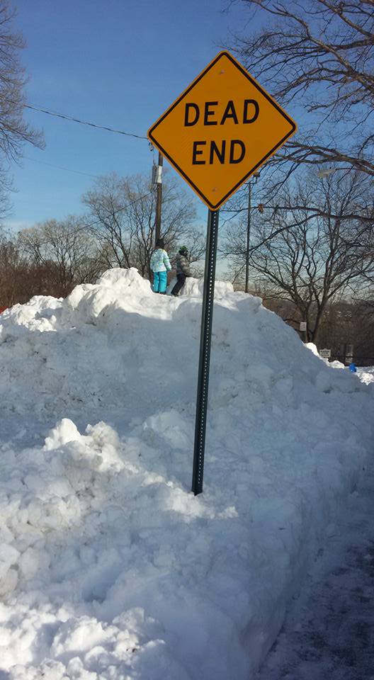 hill of snow with Dead End sign