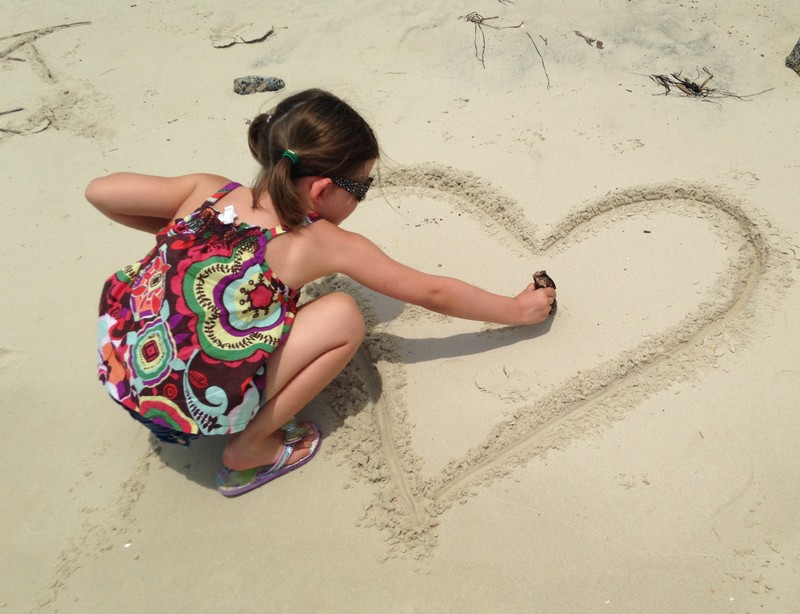 Drawing heart in the sand